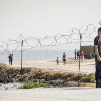 15.September 2020, LESBOS, Mytilene, Karatepe, GRIECHENLAND, Europa: Die Fluechtlinge aus Moria haben sich mit ihren wenigen Habseligkeiten zum Checkpoint begeben um ins neue Lager aufgenommen zu werden, das neue Zeltlager wird von der griechischen Armee auf einem Militaergelaende an der Kueste aufgebaut, vor dem Einlass ist Checkpoint mit Polizeikontrolle eingerichtet, wo die Fluechtlinge und ihr Gepaeck kontrolliert werden, bevor sie zur Registierung ans Tor gehen, an der Landstrasse zwischen Mytilene und Moria. Engl.:September 15, 2020 Mytilene, Karatepe, LESBOS, GREECE, Europe: The refugees from Moria have gone to the checkpoint with their few belongings to be admitted to the new camp, the new camp will be set up by the Greek army on a military site on the coast, in front of the entrance there is a checkpoint with police control, where the refugees and their luggage will be checked before they go to the gate, on the road between Mytilene and Moria, asylum, asylum seeker, border control, crisis, displaced, displacement, emmigrant, emmigration, employment, exile, exiled, human interest, immigrant, immigration, influx, migrant, migration, movement, human rights, overpopulation, people, person, political, politics, population, refugee, social, society, sea, Mediterranean, Mediterranean Sea, Civilian, EU, protection mask [DIE FOTOS DUERFEN NICHT VERAENDERT ODER IN AUSSCHNITTEN VEROEFFENTLICHT WERDEN. PHOTO MAY NOT BE CROPPED OR ALTERED IN ANY WAY!! Mindesthonorar 50 Euro maximale Online-Nutzungsdauer 12 Monate !!]